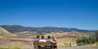 4 People sitting on bench looking out at the Painted Hills